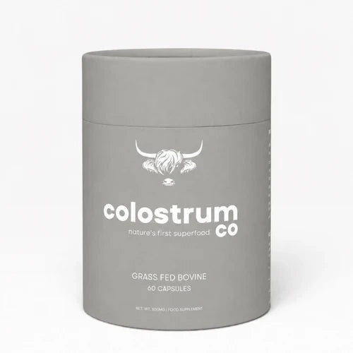A matte gray cylindrical container for Colostrum Co food capsules, featuring a white logo and text on a clean white background.